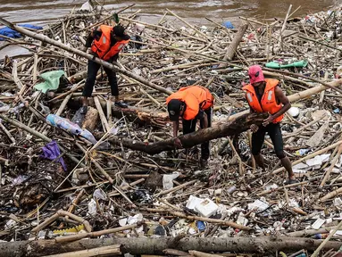 Petugas kebersihan betopeng Spiderman membersihkan sampah yang menumpuk di Pintu Air Manggarai, Jakarta, Senin (12/11). Sebagian besar sampah seperti, batang pohon, bambu, setereofoam, plastik hingga kasur. (Liputan6.com/Fery Pradolo)