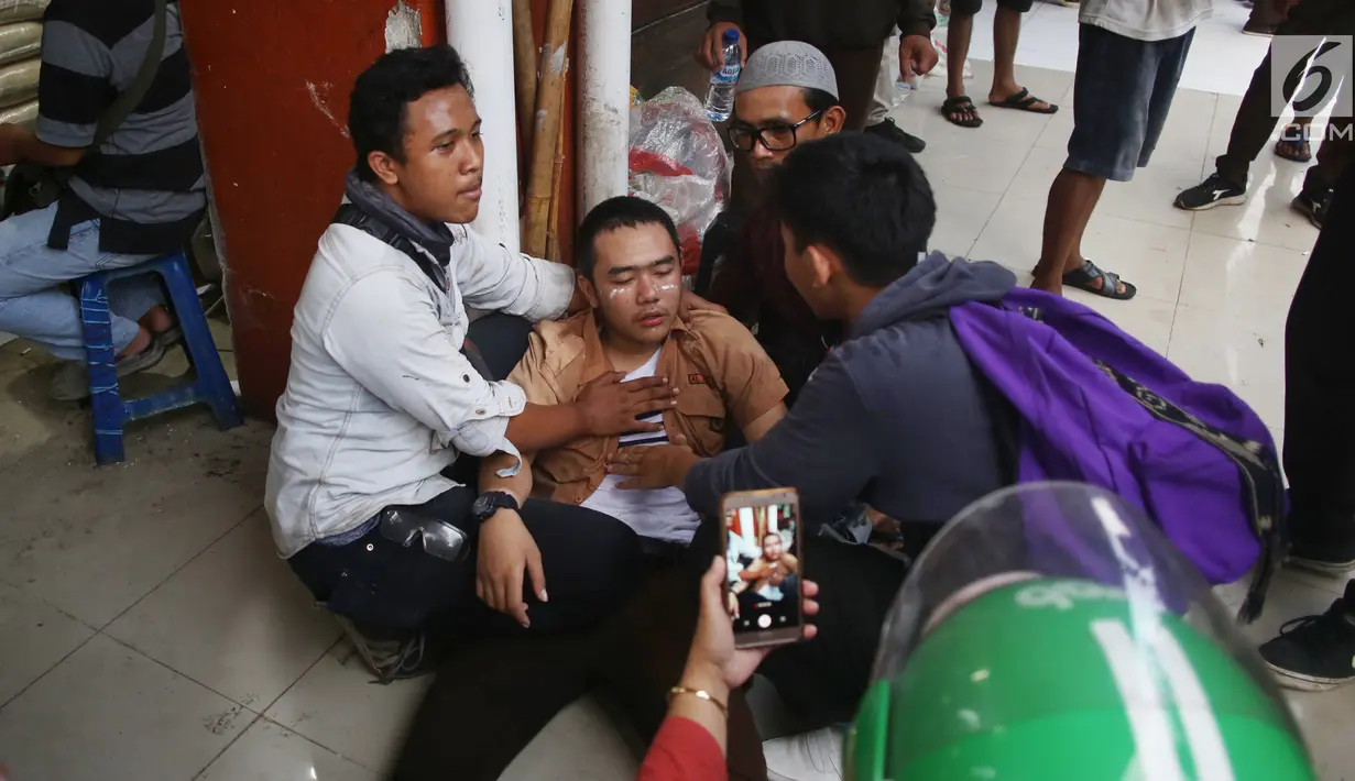 Seorang pelajar mendapat perawatan setelah terkena gas air mata dalam demonstrasi di belakang Gedung DPR, Palmerah, Jakarta, Rabu (25/9/2019). Sejumlah pelajar terluka dan sesak napas akibat gas air mata yang ditembakkan polisi. (Liputan6.com/Angga Yuniar)