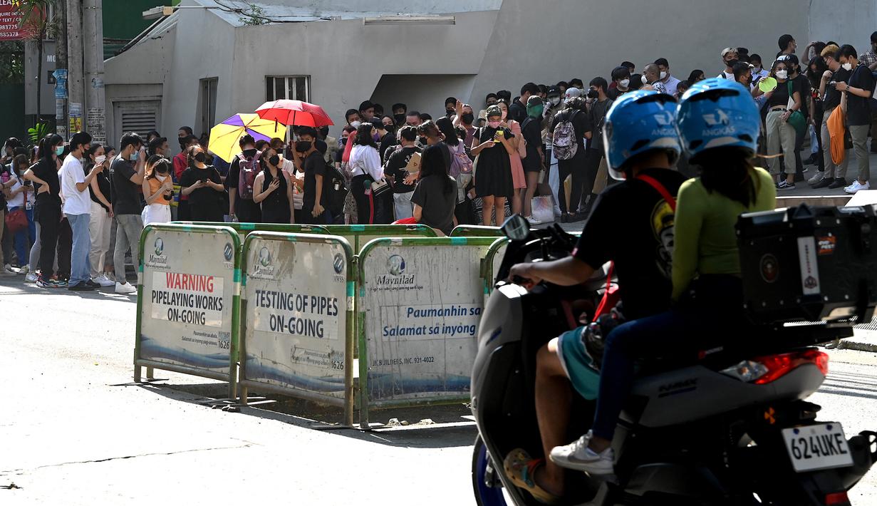 Warga menyelamatkan diri dengan keluar bangunan setelah gempa berkekuatan magnitudo 7,1 terasa di Manila, Filipina, Rabu (27/7/2022). (JAM STA ROSA/AFP)
