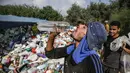 Seorang pengumpul sampah Palestina minum di tempat pembuangan sampah di Kota Gaza (29/7/2019). Kemiskinan yang terjadi akibat blokade Israel dan kurangnya kesempatan kerja membuat beberapa warga Palestina memilih bekerja mencari sampah untuk dijual. (AFP Photo/Mohammed)