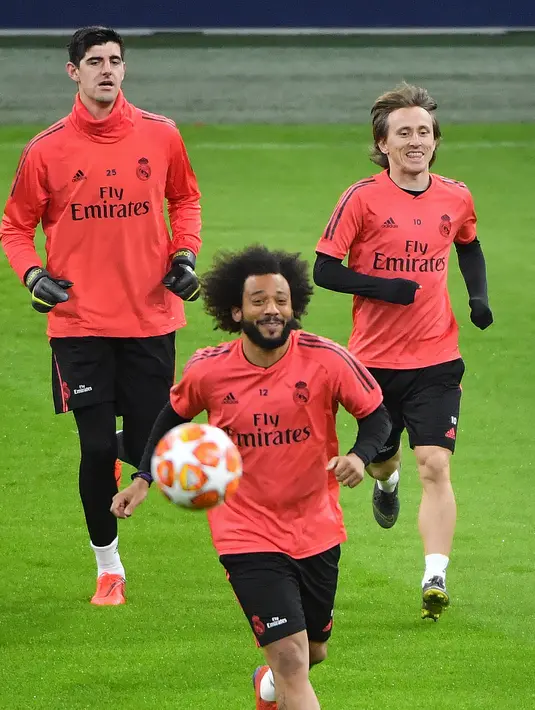 Pemain Real Madrid Marcelo (tengah) bersama Thibaut Courtois (kiri) dan Luka Modric (kanan) saat latihan jelang menghadapi Ajax Amsterdam pada babak 16 besar Liga Champions di Johan Cruijff Arena, Amsterdam, Belanda, Selasa (12/2). (EMMANUEL DUNAND/AFP)
