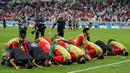 Para pemain Maroko melakukan selebrasi sujud syukur usai menaklukkan Spanyol pada laga 16 besar Piala Dunia 2022 di Stadion Education City, Selasa (6/12/2022). (AP/Martin Meissner)