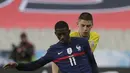 Penyerang Prancis, Ousmane Dembele mengontrol bola dari kawalan pemain Ukraina, Vitaliy Mykolenko pada pertandingan kualifikasi Piala Dunia D di stadion Start de France, di Saint Denis, utara Paris, Kamis (25/3/2021). Prancis bermain imbang atas Ukraina 1-1. (AP Photo/Thibault Camus)