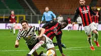 Striker Manchester United, Daniel James (kiri) terjatuh saat perebutan dengan bek AC Milan, Fikayo Tomori dalam laga leg kedua babak 16 besar Liga Europa 2020/2021 di San Siro Stadium, Milan, Kamis (18/3/2021). Manchester United menang 1-0 atas AC Milan. (AFP/Marco Bertorello)