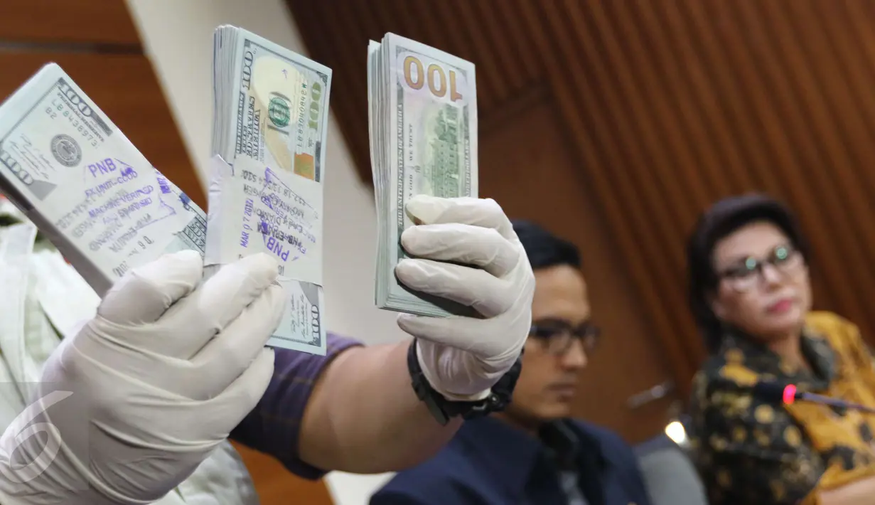 Petugas memperlihatkan uang yang berhasil disita dari pejabat PT PAL terkait dugaan suap pengadaan kapal ke Filipina, Jakarta, Jumat (31/3). KPK menyita 25 ribu dolar AS dan menahan 4 tersangka. (Liputan6.com/Helmi Afandi)