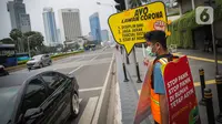 Relawan yang tergabung dalam Gerakan Mahasiswa Cegah Covid-19 membawa poster 'Ayo Lawan Corona' saat kampanye di Pelican Cross kawasan Thamrin, Jakarta, Senin (23/3/2020). (Liputan6.com/Faizal Fanani)