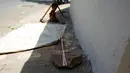 Sebuah batu tampak terikat di kaki Shivani (15 bulan) di lokasi konstruksi di Ahmedabad, India, 20 April 2016. Kepala perlindungan anak pada Save the Children India mengatakan fasilitas penitipan bayi jarang ada dan biasanya mahal. (REUTERS/Amit Dave)