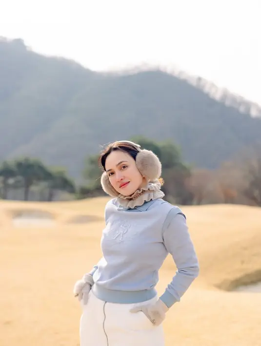 Ia kenakan outfit berlapis yang terdiri dari long sleeve dan sleeveless sweater abu-abu. Dipadu dengan ruffle collar dan celana putih [@shandyaulia]