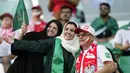 Dua fans wanita Arab Saudi berpose dengan pendukung Polandia sebelum pertandingan grup C Piala Dunia antara Polandia dan Arab Saudi, di Education City Stadium di Al Rayyan, Qatar, Sabtu, 26 November 2022. (AP Photo/Aijaz Rahi)
