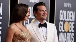 Irina Shayk dan aktor Bradley Cooper berpose saat menghadiri Golden Globe Awards ke-76 di Beverly Hills, California (6/1). Irina tampil mengenakan gaun emas. Sedangkan Bradley Cooper tampil dengan tuksedo putih. (AP Photo/Jordan Strauss)