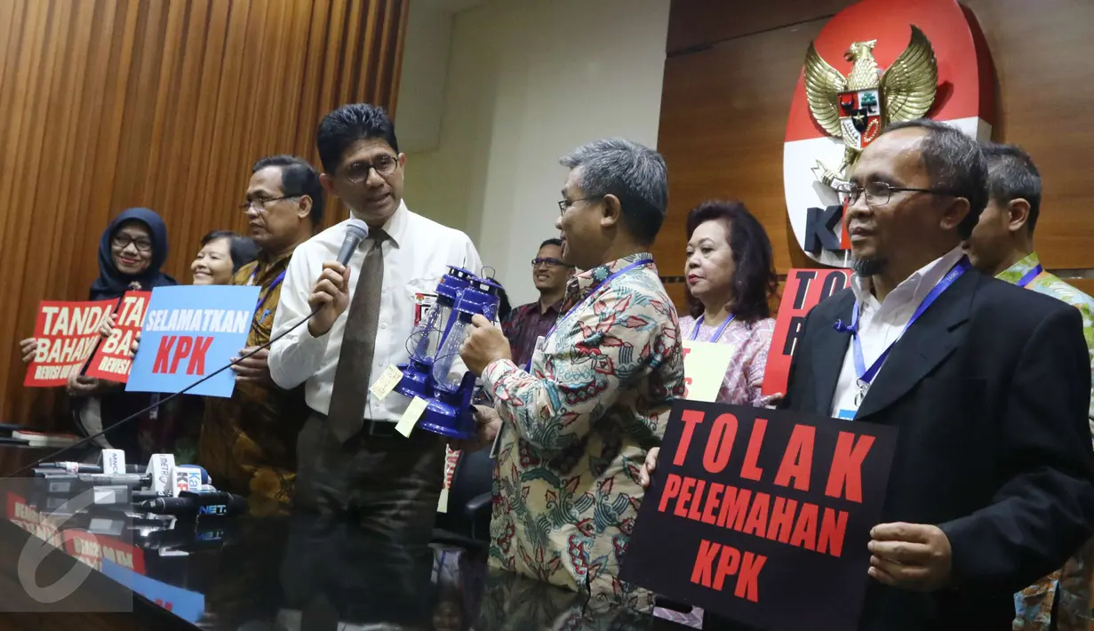 Wakil Ketua KPK Laode M Syarif menerima lentera yang diserahkan oleh Wakil Ketua Forum Rektor Asep Saefuddin sebagai simbol dukungan kepada KPK usai pertemuan di Gedung KPK Jakarta, Jumat (17/3). (Liputan6.com/Helmi Afandi)