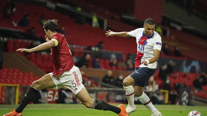 Penyerang Paris Saint Germain (PSG), Kylian Mbappe berebut bola gelandang Manchester United atau MU, Harry Maguire pada matchday kelima Grup H Liga Champions di Stadion Old Trafford, Kamis (3/12/2020) dinihari WIB. MU keok 1-3 dari PSG. (AP Photo/Dave Thompson)