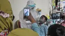 Orang tua mendampingi anaknya saat menjalani tes Covid-19 di GOR Kecamatan Makasar, Jakarta, Senin (17/5/2021). Pemkot Jakarta Timur menggelar tes Covid-19 gratis bagi warga yang baru tiba di Ibu Kota guna mencegah penyebaran virus Corona usai mudik. (merdeka.com/Iqbal S Nugroho)