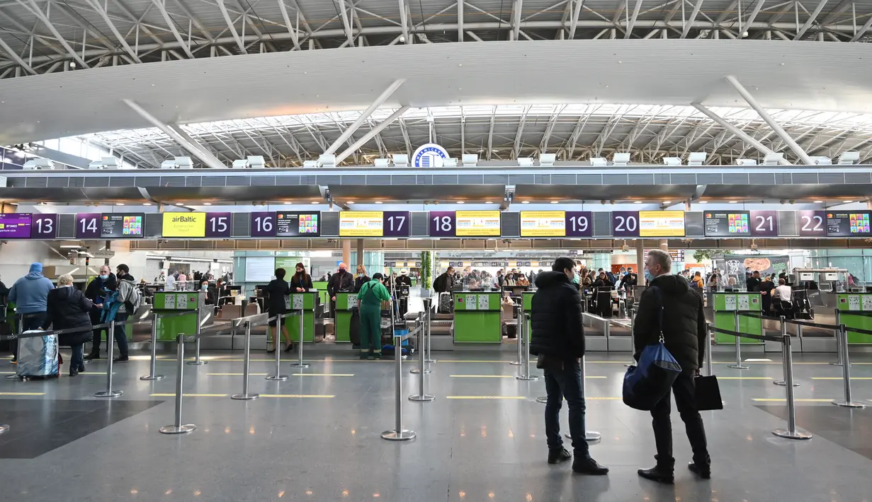 Pelancong menunggu di konter check-in sebelum penerbangan mereka di bandara Boryspil, luar Kiev, 13 Februari 2022. Ukraina berjanji menjaga wilayah udaranya terbuka untuk perjalanan internasional setelah negara Barat memperingatkan pasukan Rusia dapat menyerang kapan saja. (Sergei Supinsky/AFP)
