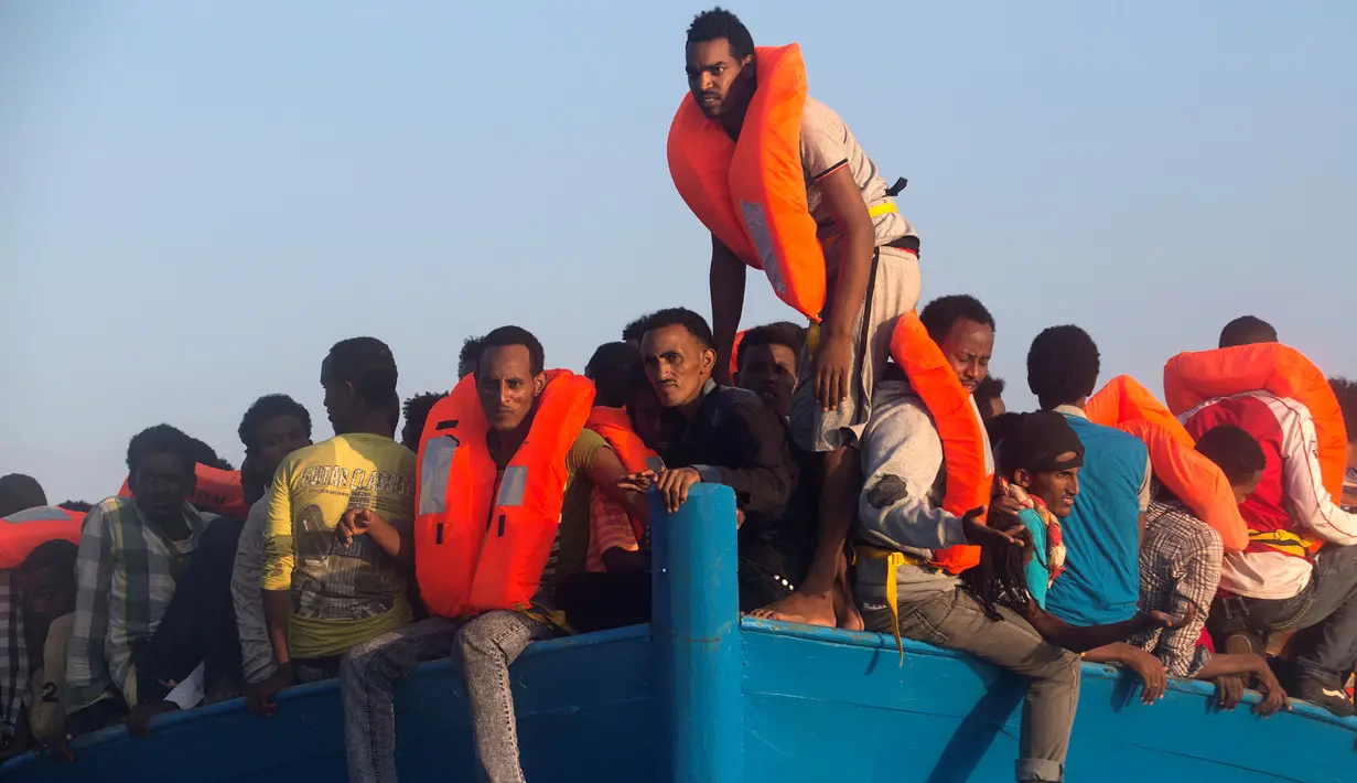 Sejumlah imigran menunggu di kapal kayu untuk diselamatkan oleh petugas di lepas panti Libya, Laut Mediterania, Senin (29/8). Para penjaga pantai Italia berhasil menyelamatkan sekitar 6.500 imigran dari Eritrea dan Somalia. (REUTERS/Giorgos Moutafis)