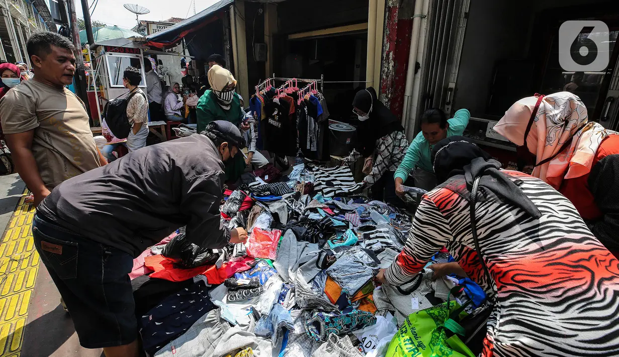 Pengunjung memilih pakaian yang dijual di Pasar Tanah Abang, Jakarta Pusat, Minggu (2/5/2021). Pusat Grosir Pasar Tanah Abang ramai didatangi pengunjung yang berbelanja menjelang Lebaran dengan berdesak-desakan tanpa jaga jarak. (Liputan6.com/Johan Tallo)