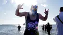 Seorang peserta mengenakan topeng saat mengikuti acara renang Polar Bear Club di Coney Island, New York (1/1). Mereka mengenakan kostum saat berenang di pantai Samudera Atlantik dengan suhu 17 derajat Fahrenheit. (Yana Paskova/Getty Images/AFP)
