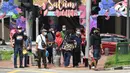 Sejumlah orang mengenakan masker untuk mengantisipasi terpapar virus corona COVID-19 di Pasar Geylang Serai, Singapura, Kamis (21/5/2020). Hari Raya Idul Fitri tahun ini akan dirayakan di tengah pandemi virus corona COVID-19. (Roslan RAHMAN/AFP)