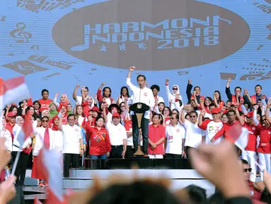 Presiden RI, Joko Widodo (tengah) menyapa peserta Harmoni Indonesia 2018 di Kompleks Gelora Bung Karno, Jakarta, Minggu (5/8). Harmoni Indonesia adalah bernyanyi bersama secara serentak lagu-lagu kebangsaan di 34 kota. (Liputan6.com/Helmi Fithriansyah)
