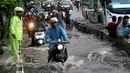 Polisi lalu lintas mengatur kendaraan yang melintas akibat banjir di depan Mall Gandaria City, Jakarta, Sabtu (27/8). Hujan intensitas tinggi membuat jalan tersebut banjir setinggi 30-50 cm. (Liputan6.com/Helmi Afandi)
