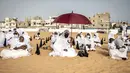 Pengikut komunitas Layene Senegal menunggu dimulainya salat Tabaski (Idul Adha) di lingkungan populer Yoff di Dakar, Rabu (21/7/2021). Para jemaah mengenakan pakaian putih untuk merayakan hari raya umat Muslim yang dikenal di Senegal sebagai 'Tabaski'. (JOHN WESSELS / AFP)