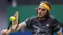 Petenis Yunani, Stefanos Tsitsipas berusaha mengembalikan bola pukulan Novak Djokovic dari Serbia pada perempat final tunggal putra tenis Shanghai Masters di Qizhong Forest Sports City Tennis Center di Shanghai, China (11/10/2019). Tsitsipas menang 3-6, 7-5, 6-3 atas Djokovic. (AP Photo/Andy Wong)