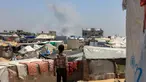 Seorang anak Palestina melihat kepulan asap mengepul dari kejauhan selama pemboman Israel di Rafah, Jalur Gaza Selatan pada 11 Juni 2025. (Foto oleh AFP)