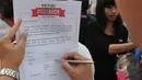 Seorang warga menulis petisi mendukung Gubernur Ahok di Bundaran HI, Jakarta, Minggu (1/3/2015). Aksi mereka sebagai bentuk dukungan kepada Ahok yangingin membongkar dana siluman di Pemprov DKI (Liputan6.com/Herman Zakharia)