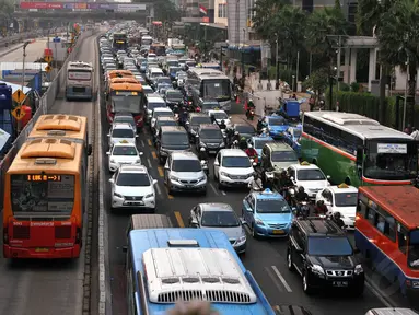 Beberapa pengguna jalan dan armada bus Transjakarta saat melintas di Jalan MH Thamrin, Jakarta, Rabu (4/6/14). (Liputan6.com/Johan Tallo)