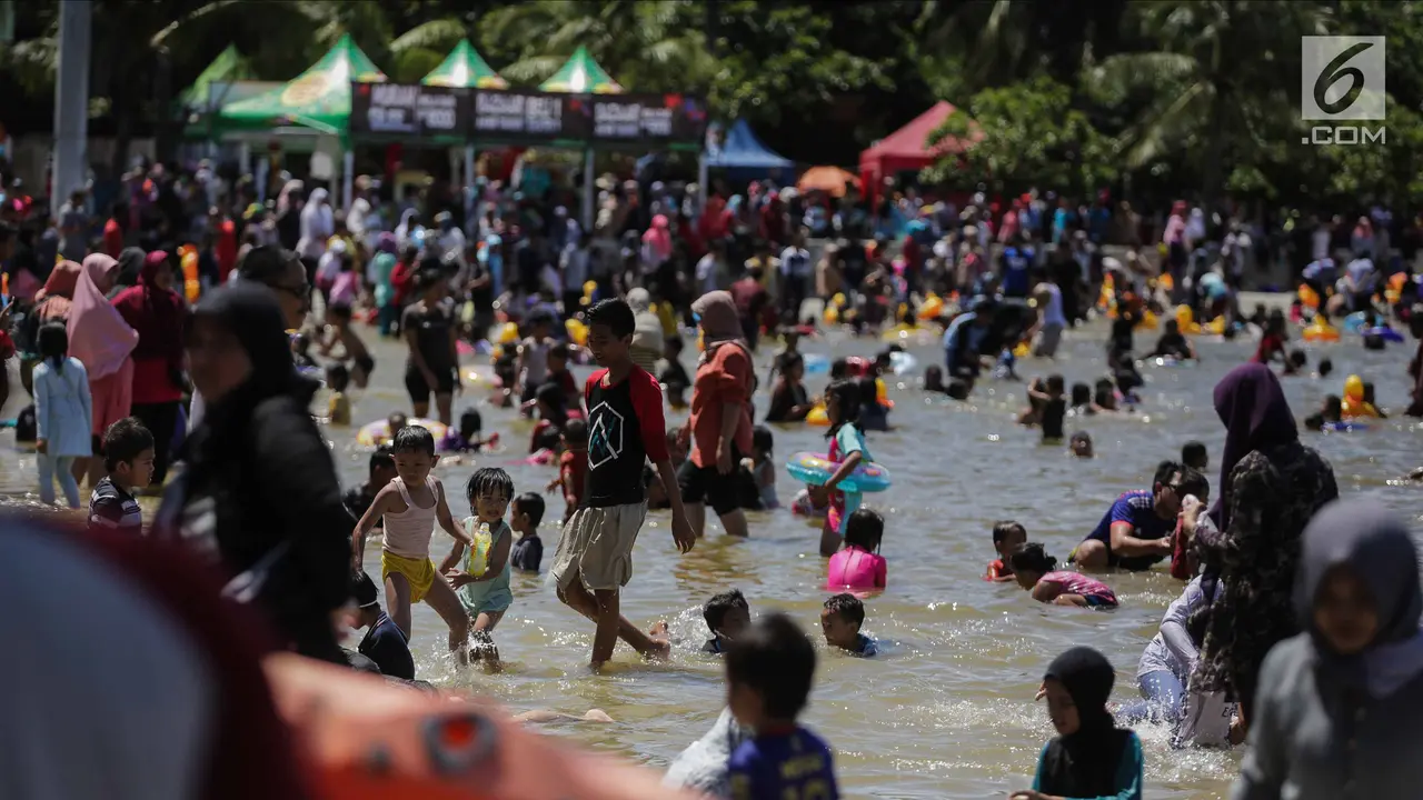 Libur Natal, Warga Menikmati Liburan Murah Meriah di Pantai Ancol