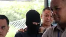 Dengan mengenakan baju tahanan berwarna gelap, dan penutup wajah ia datang didampingi oleh pihak Polsek Metro Tamansari, Jakarta Barat. (Adrian Putra/Bintang.com)