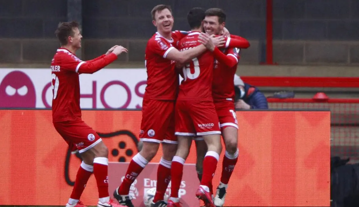 Para pemain Crawley Town merayakan gol yang dicetak oleh Jordan Tunnicliffe ke gawang Leeds United pada laga Piala FA di Stadion Broadfield, Minggu (10/1/2021). Leeds United takluk dengan skor 3-0. (AP Photo/Ian Walton)