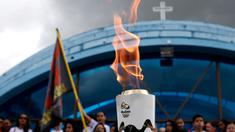 Warga menyaksikan parade obor Olimpiade yang melintas di Itamaraju, Kota Bahia , Brasil,(19/5/2016). Olimpiade akan dilaksanakan di Rio De Jeneiro.  (AFP/Marcos de Paula)