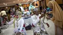 Pasangan pengantin bersiap mengikuti nikah massal di Surabaya, Jawa Timur, Rabu (18/12/2019). Sebanyak 60 pasangan pengantin mengikuti nikah massal yang digelar Dinas Sosial Kota Surabaya. (JUNI KRISWANTO/AFP)