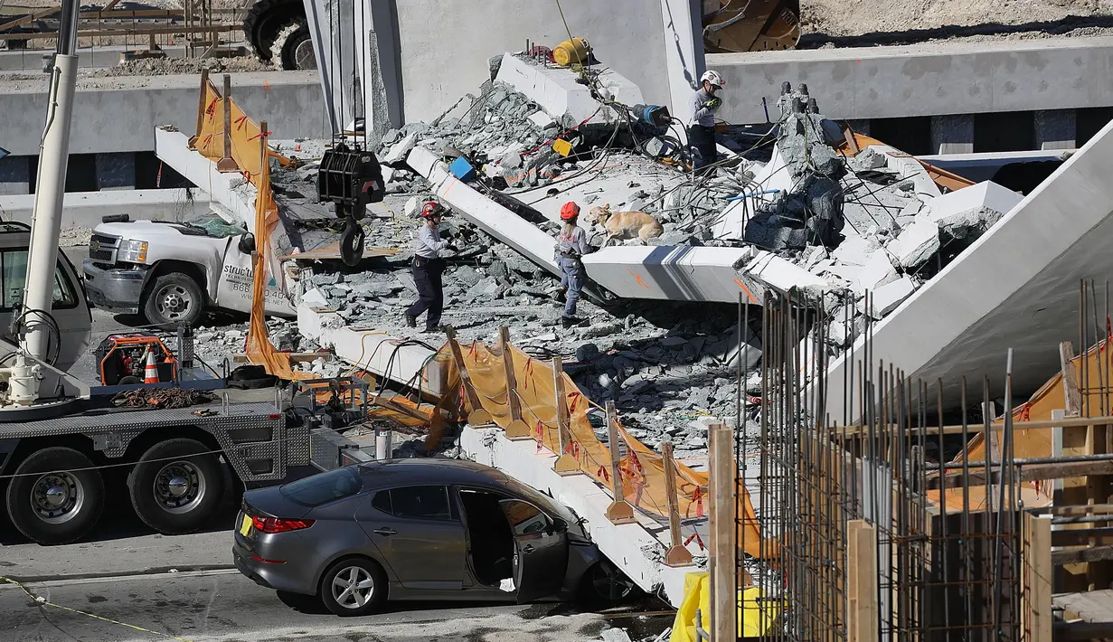 Tim Penyelamatan Kebakaran Miami-Dade Fire dan unit penyelamatan lainnya berusaha mengevakuasi korban runtuhnya jembatan pejalan kaki di Miami, Florida (15/3). Beberapa orang dilaporkan tewas dalam insiden ini. (Joe Raedle / Getty Images / AFP)