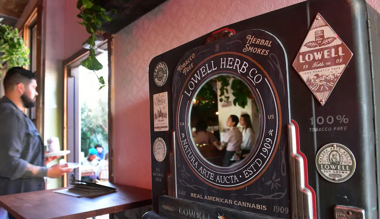 Pelayan membawa makanan dari ruangan menuju keluar di Lowell Cafe di Hollywood Barat, California  (30/9/2019). Kafe ini menawarkan pengunjung berbagai produk gulma dan berharap dapat menyaingi toko kopi terkenal di Amsterdam. (AFP Photo/Frederic J. Brown)