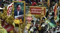 Sebuah perahu membawa foto mendiang Raja Thailand Bhumibol Adulyadej selama festival Rab Bua di Samut Prakan (4/10). (AFP Photo/Lillian Suwanrumpha)