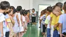 Anak-anak memperkenalkan diri mereka dibantu guru di taman kanak-kanak lokasi relokasi wilayah Sansui, Provinsi Guizhou, China, 31 Agustus 2020. Guizhou melakukan segala upaya untuk membangun atau memperluas 669 sekolah di lokasi relokasi tersebut. (Xinhua/Yang Wenbin)