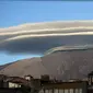 Awan lenticular yang terlihat di Sicily, Italia, terbentuk akibat adanya tiupan uap air melewati puncak gunung dan menetes pada sisi lain (Dailymail.com).