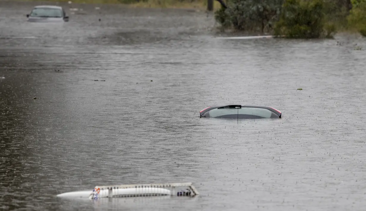 Kendaraan tenggelam di halaman banjir dekat Londonderry di pinggiran barat Sydney, Australia (22/3/2021). Ratusan orang telah diselamatkan dari banjir yang telah merendam puluhan kota di negara bagian terpadat di Australia, New South Wales. (AP Photo/Mark Baker)