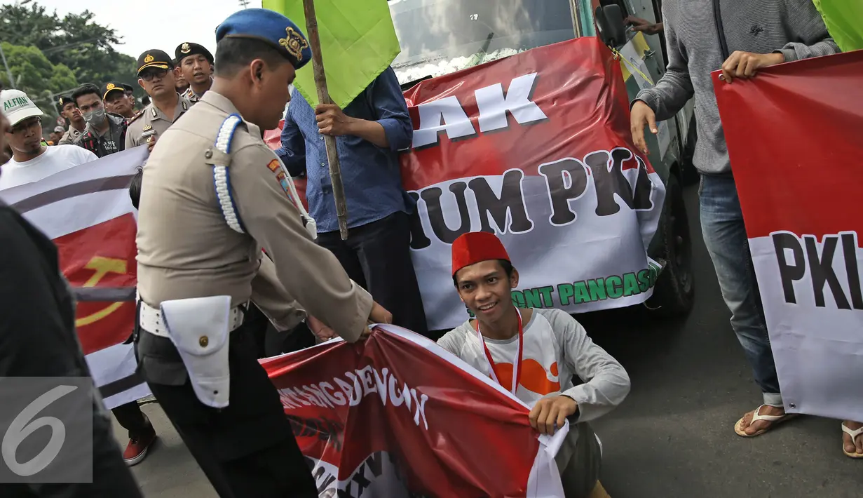 Aparat berusaha membubarkan massa aksi dari Front Pancasila saat berusaha masuk menuju Hotel Aryaduta, Jakarta, Senin (18/4). Mereka menolak Simposium PKI yang bertentangan dengan Pancasila dan UUD 1945. (Liputan6.com/Faizal Fanani)