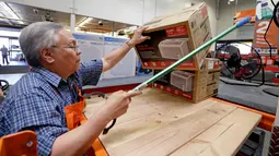 Manager toko mengambilkan pendingin udara untuk pelanggan menjelang gelombang panas di toko perlengkapan Home Depot di Seattle, Selasa (1/8). Suhu panas mendekati 100 derajat diperkirakan terjadi di wilayah itu pada Kamis 3 Agustus. (AP/Elaine Thompson)