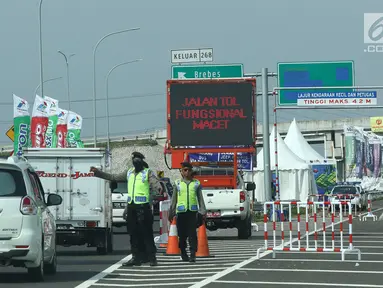 Petugas memberi informasi pemudik saat penutupan jalur fungsional tol Brebes-Batang, Jawa tengah, Rabu (21/6). Penutupan tersebut disebabkan menumpuknya kendaraan menuju jalur fungsional tol Brebes-Batang. (Liputan6.com/Gempur M Surya)