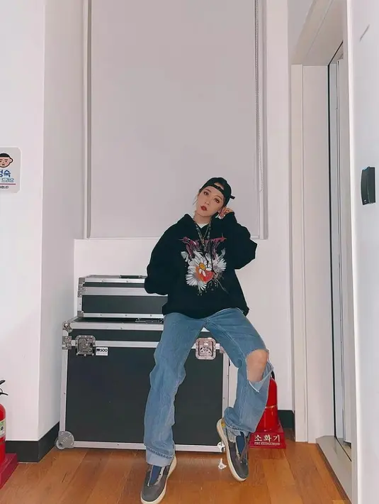 Moonbyul tampil kece dengan memadukan oversized hoodie warna hitam dengan ripped jeans. Ia juga melengkapi penampilannya dengan aksesori kalung dan dad hat. (Instagram/mo_onbyul).