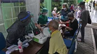 Petugas memeriksa kesehatan warga lansia sebelum mengikuti vaksinasi Covid-19 di Puskesmas Kecamatan Senen, Jakarta Pusat, Selasa (23/2/2021). Vaksinasi untuk Lansia akan dimulai di ibu kota provinsi untuk seluruh provinsi di Indonesia, di prioritaskan di Jawa-Bali. (Liputan6.com/Herman Zakharia)
