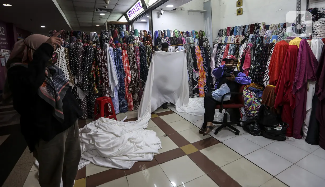 Pedagang merapikan kain di pusat penjualan pakaian dan tekstil Pasar Tanah Abang Blok B, Jakarta, Selasa (19/1/2021). Kementerian Perindustrian memproyeksikan kinerja tekstil 2021 akan bergerak positif, meski masih tipis di level 0,93 persen. (Liputan6.com/Johan Tallo)