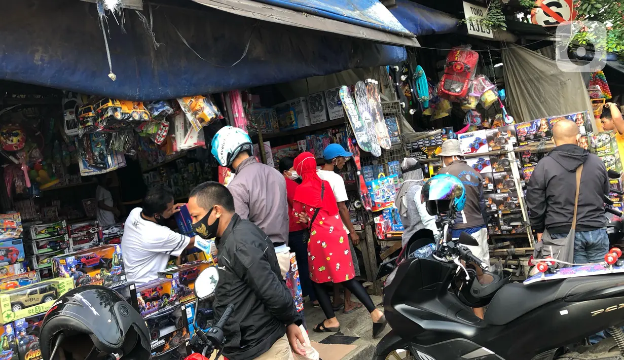 Warga memilih mainan tanpa menjaga jarak di Pasar Gembrong, Jakarta Timur, Minggu (31/5/2020). Meski penerapan masa Pembatasan Sosial Berskala Besar (PSBB) di Jakarta masih berlaku, namun pasar yang khusus menjual pernak-pernik mainan anak ini kembali dipadati warga. (Liputan6.com/Immanuel Antonius)