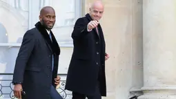 Mantan penyerang Pantai Gading, Didier Drogba berjalan bersama Presiden FIFA Gianni Infantino saat tiba di Istana Elysee di Paris, (21/2). Didier Drogba diundang makan siang Presiden Prancis dan Presiden Liberia. (AFP Photo/Ludovic Marin)