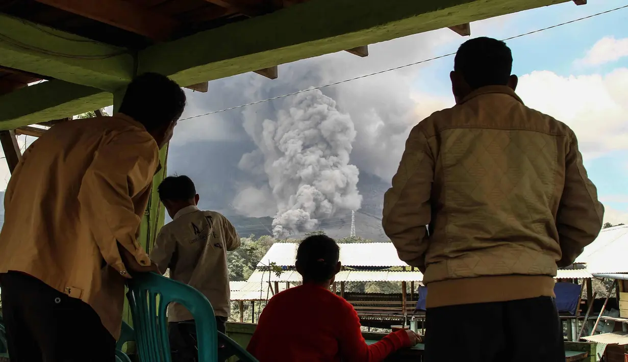 Warga desa berkumpul menyaksikan gunung berapi Gunung Sinabung yang memuntahkan abu tebal di Karo, Sumatra Utara (18/12). Gunung Sinabung kembali aktif pada tahun 2010 untuk pertama kalinya dalam 400 tahun. (AFP Photo/Ivan Damanik)