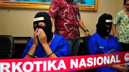 Salah satu kurir sabu, SA (kiri), menangis saat rilis barang bukti dan tersangka di Kantor BNN, Jakarta, Selasa (19/5/2015). SA dan AN ditangkap aparat BNN dengan barang bukti 12,29 kilogram sabu. (Liputan6.com/Yoppy Renato)